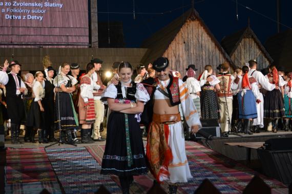 Dievča a chlapec v detvianskom kroji a účinkujúci na pódiu Dievča a chlapec v detvianskom kroji a účinkujúci na pódiu