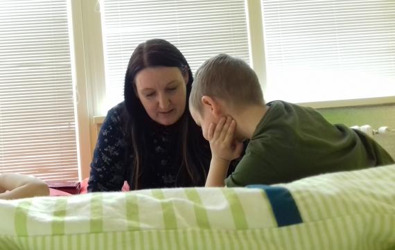 Mama číta deťom, chlapec počúva Mama číta deťom, chlapec počúva