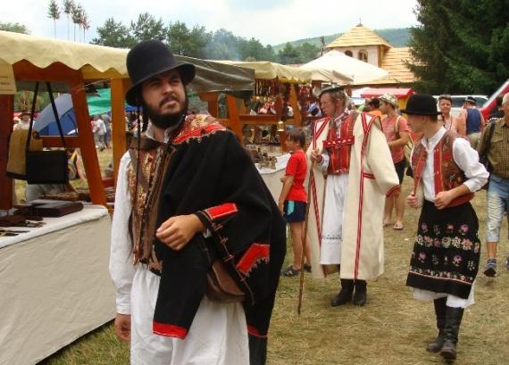 Návštevníci jarmoku v krojoch medzi stánkami Návštevníci jarmoku v krojoch medzi stánkami
