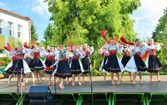 Na pódiu tancujú dievčatá v krojoch šatkový tanec Na pódiu tancujú dievčatá v krojoch šatkový tanec