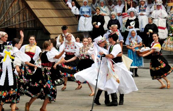 Folkloristi na pódiu, tanec novomanželov v kroji Folkloristi na pódiu, tanec novomanželov v kroji